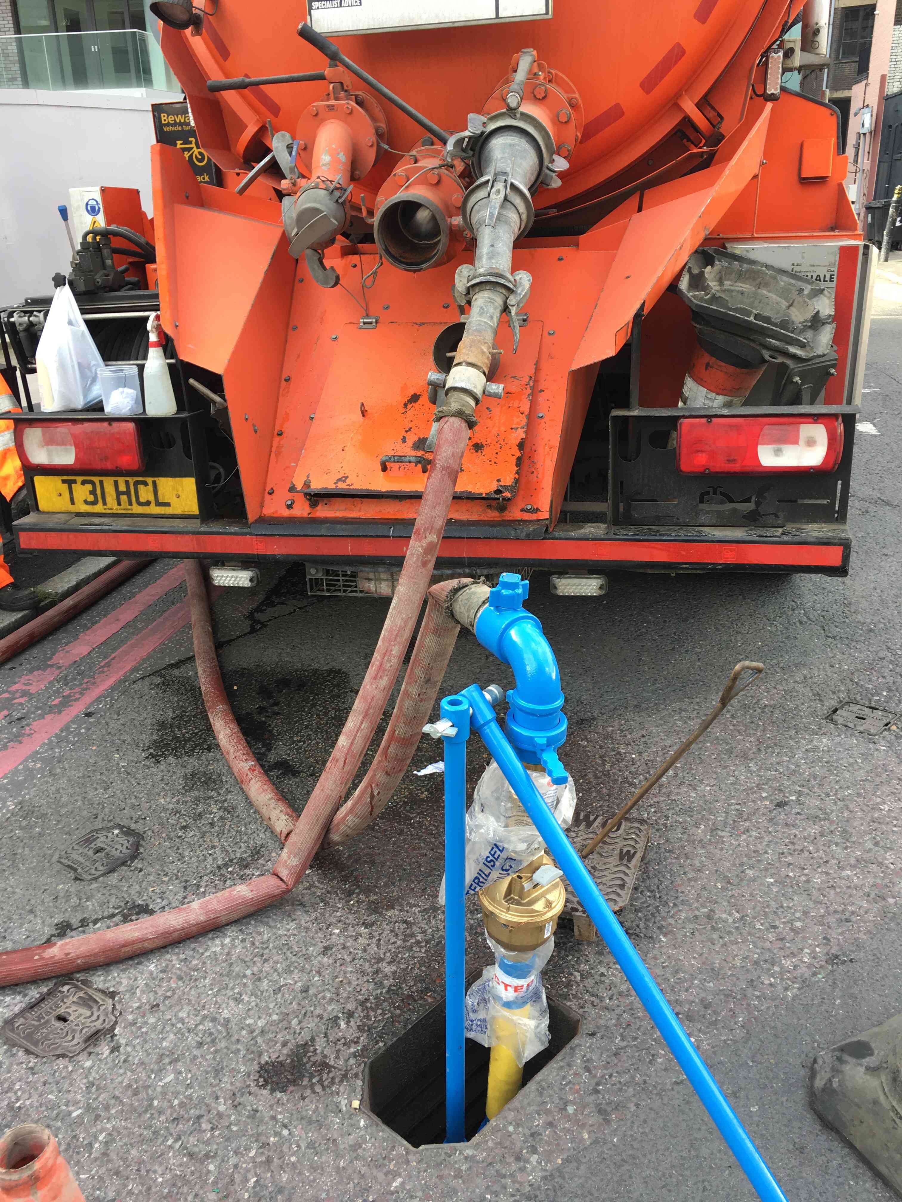Vacuum tanker removing sludge from industrial site