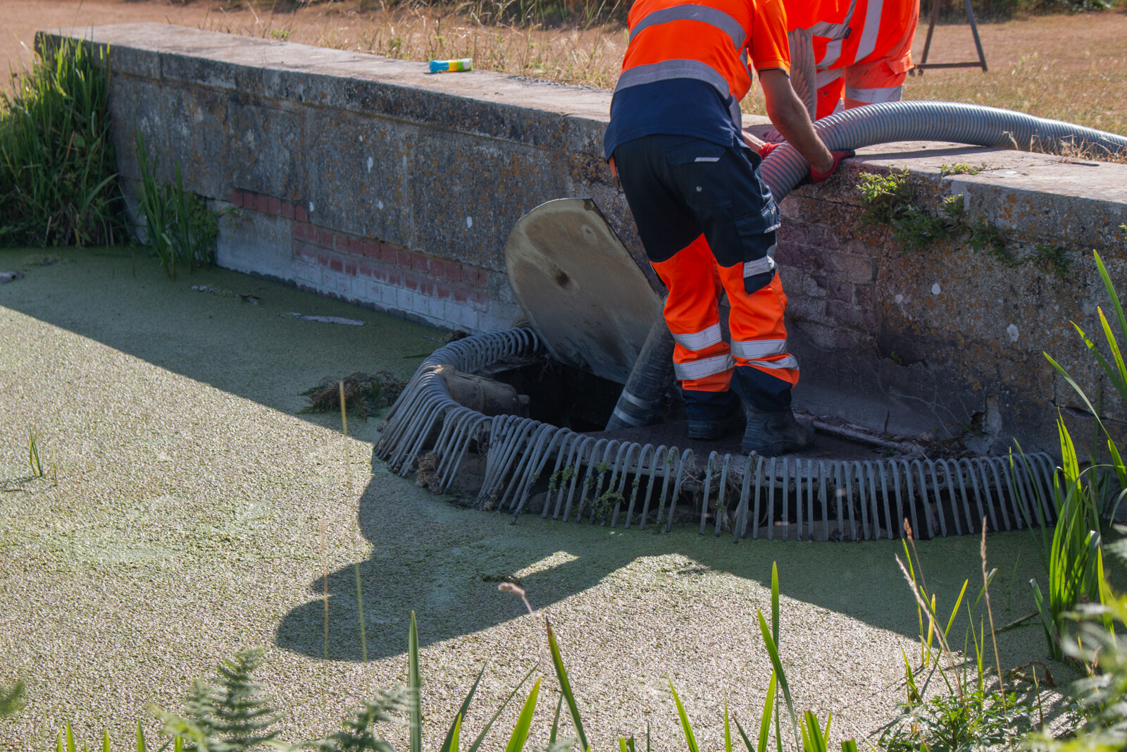 Engineer lowering CCTV crawler into manhole
